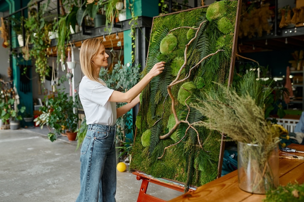 young woman creating plant art with moss