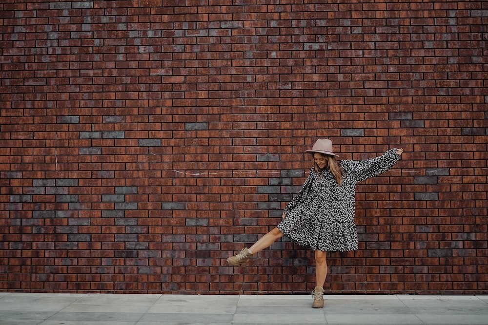 Woman wearing a drop waist dress and a hat
