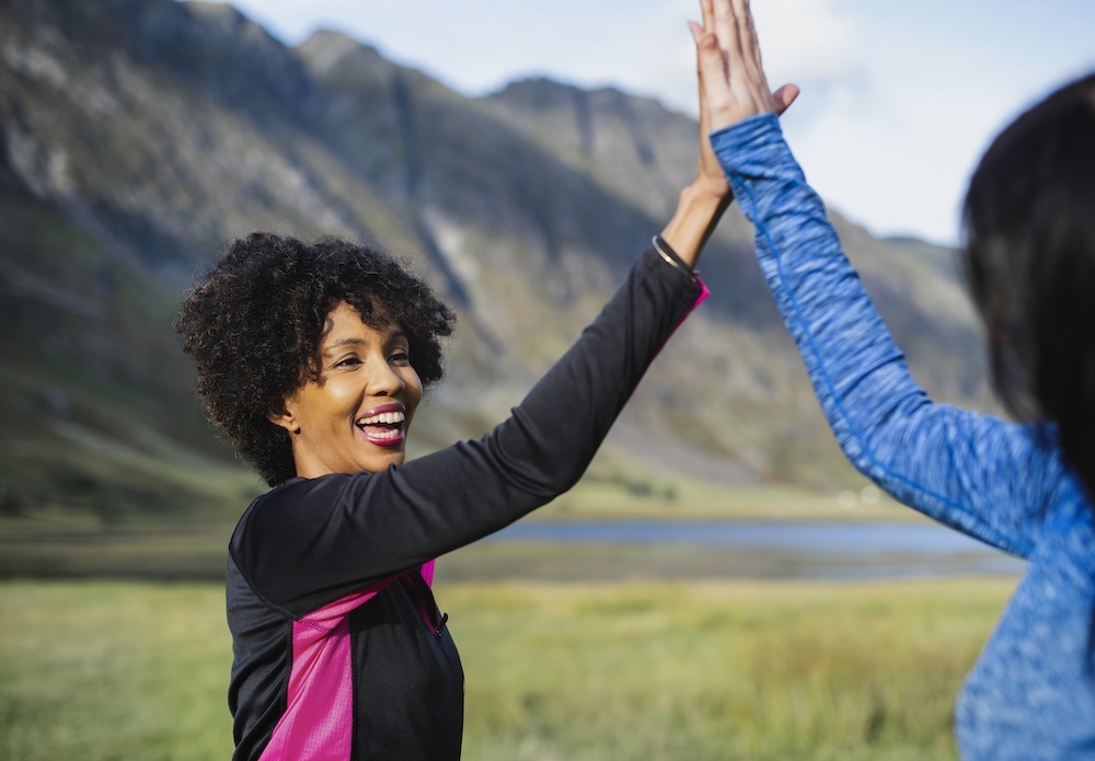 Two women giving high five after physical activity