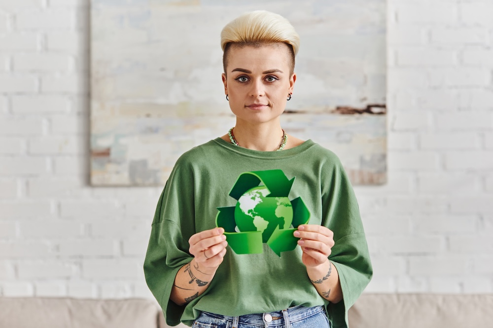 Woman holding a green recycle sign