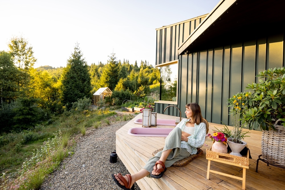 Woman sitting outside her off-grid retreat