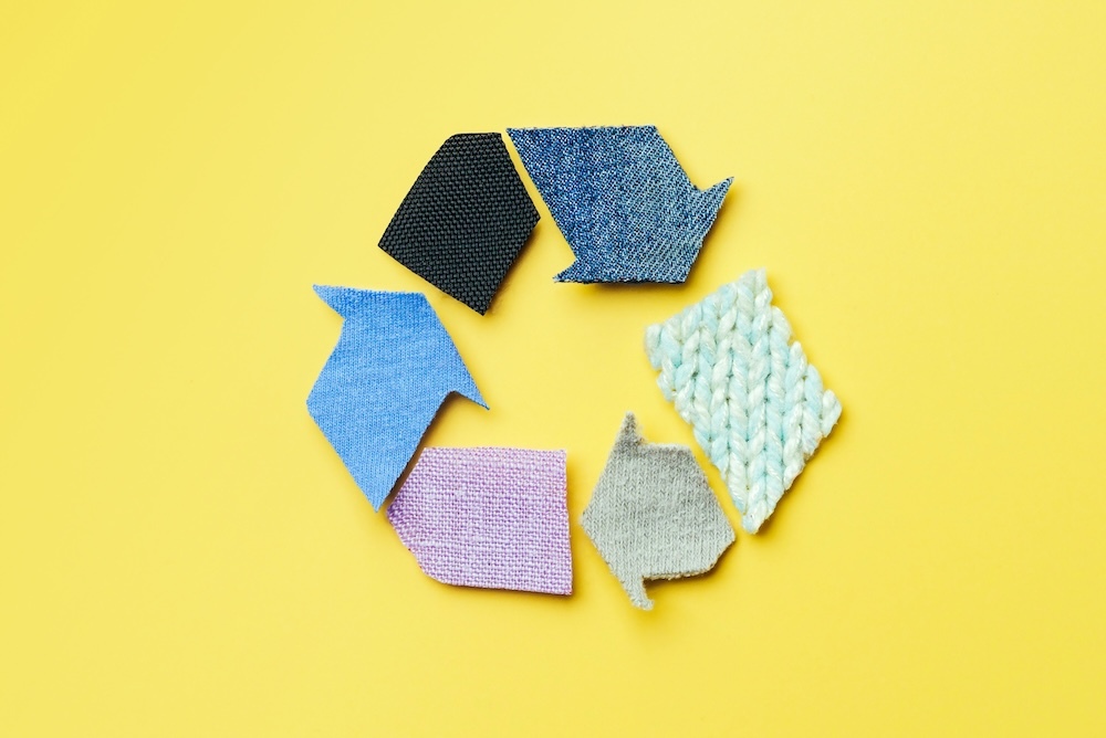 Different fabric cut in arrows to shape a recycle symbol