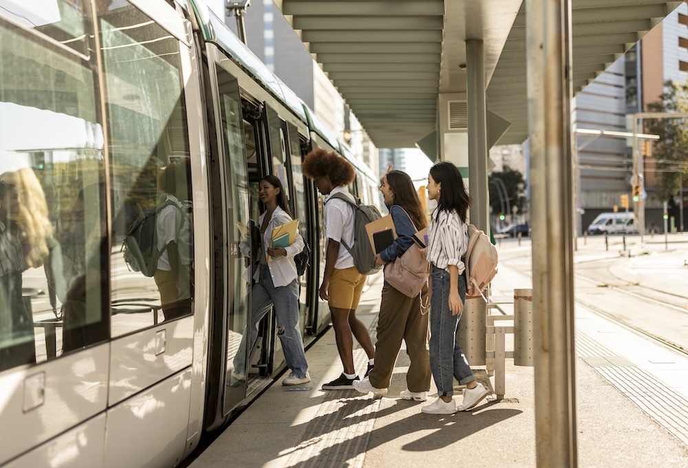 Group of friends stepping onto a tram