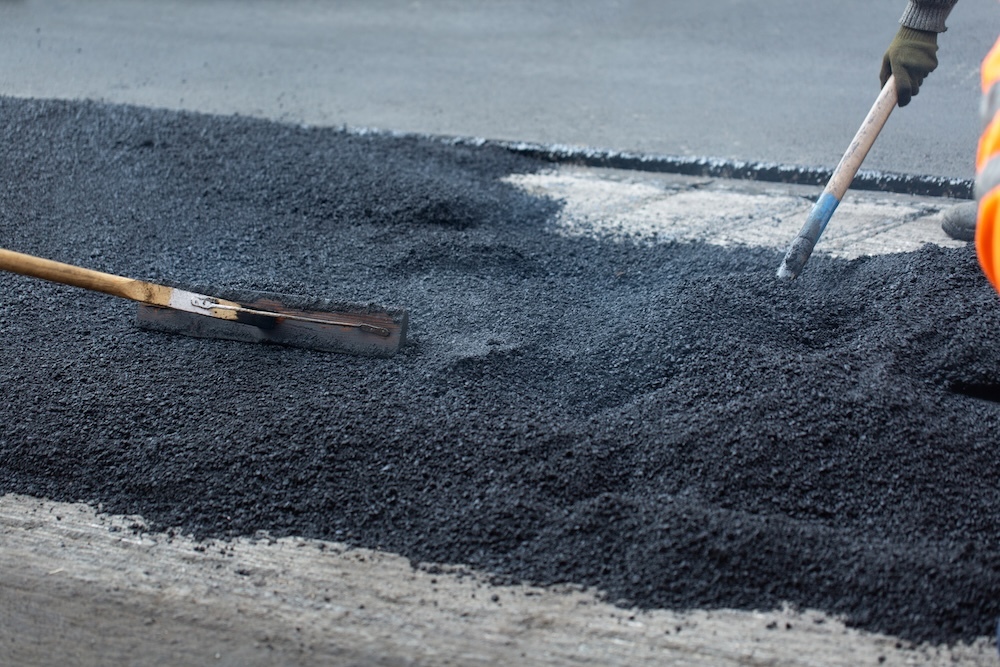 Group of road workers smoothing out asphalt