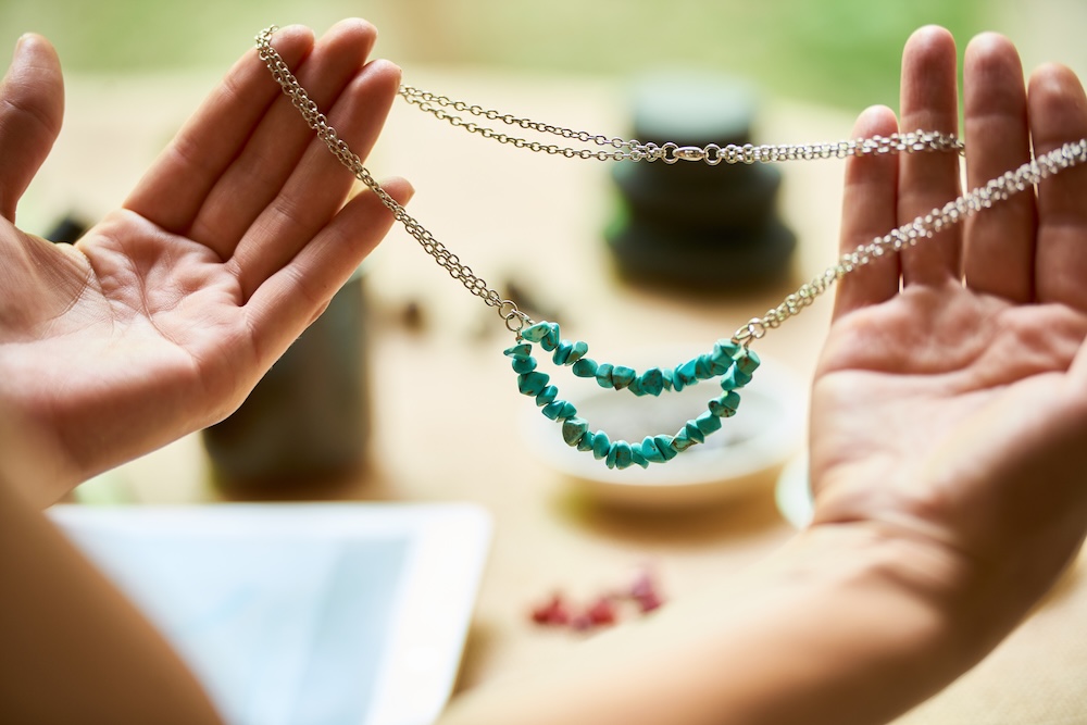 Hands holding a handmade neckless