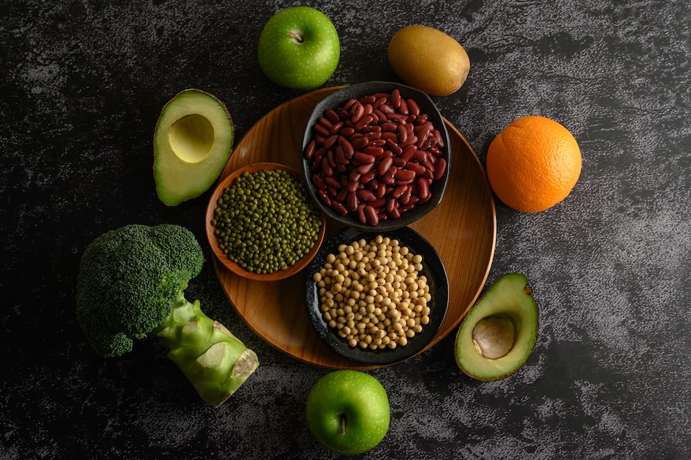 healthy plant-based legumes and fruit on a black table