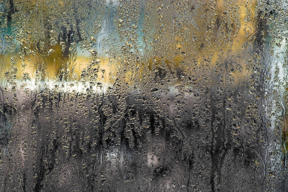 water drops on a wet glass with abstract colors