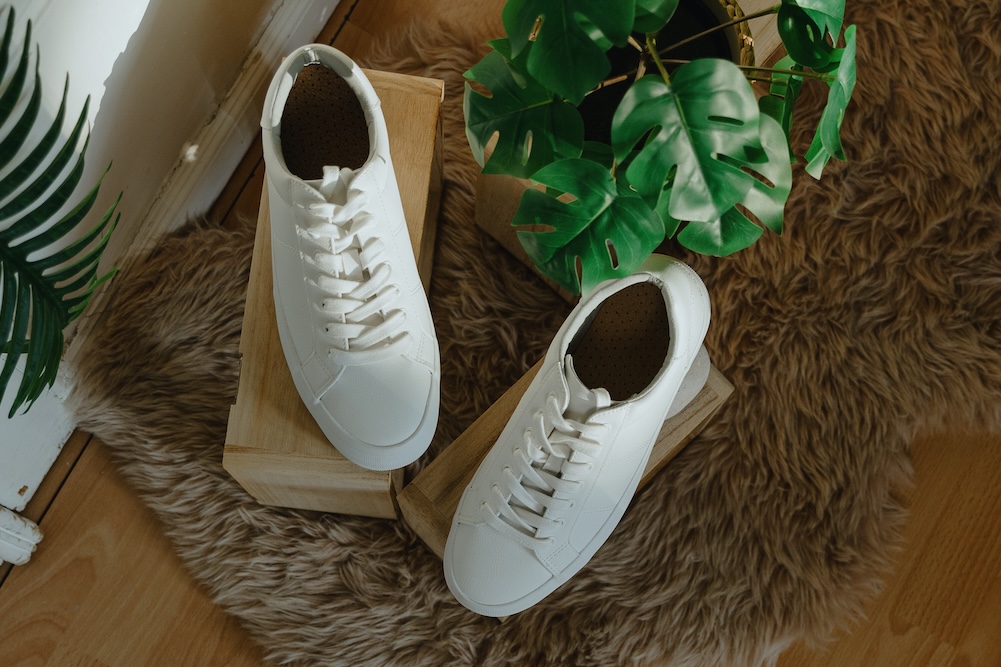 White shoes sitting on a wooden box with plants