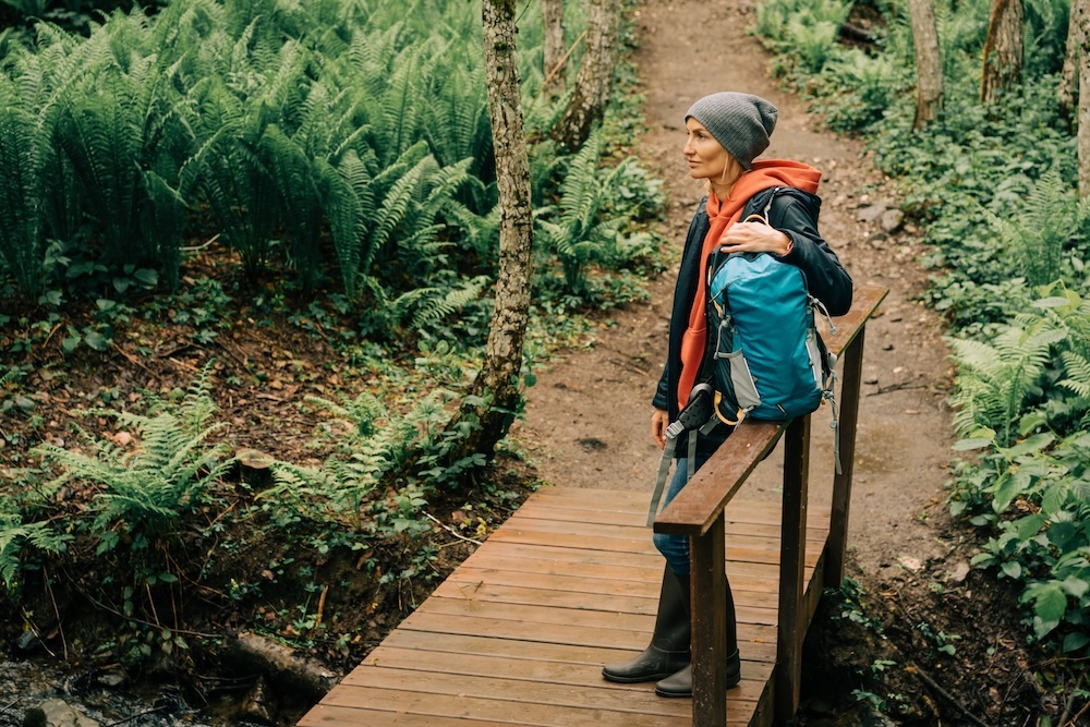 Woman on a hike wearing a raincoat carrying a backpack