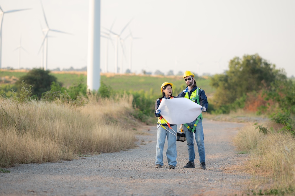 Environmental engineer reviewing blueprints onsite