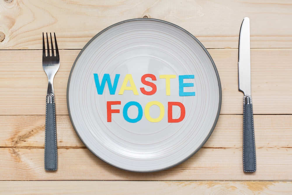 Food waste spelled out on plate with knife and fork