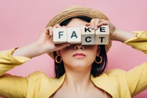 woman holding the word fake