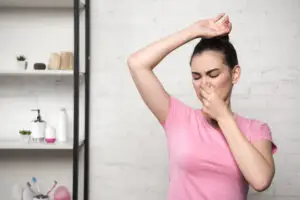 woman holding nose smelling bad body odor