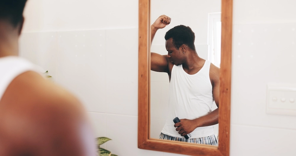 man smelling armpits using natural deodorant