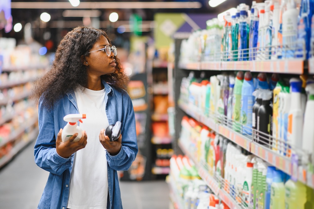 woman reading labels and evaluating products in a grocery aisle