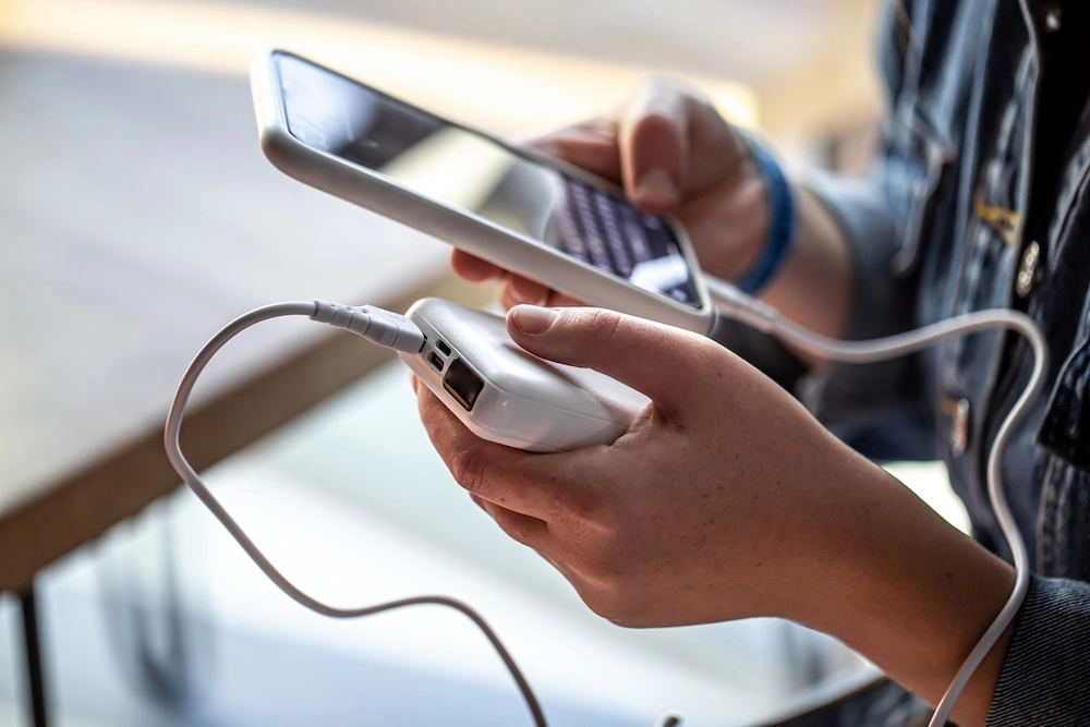 woman holding iphone plugged into a powerbank