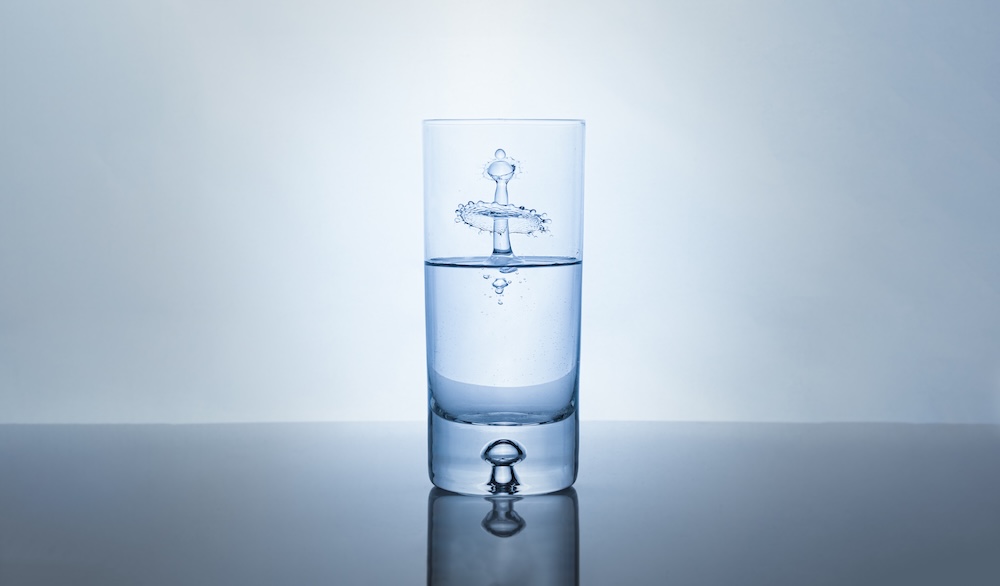 drop of water into a glass of ionized water creating a splash