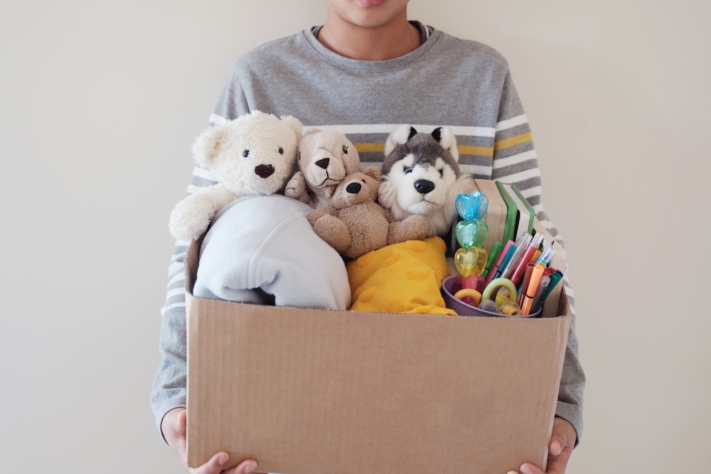 young boy holding a box of toys