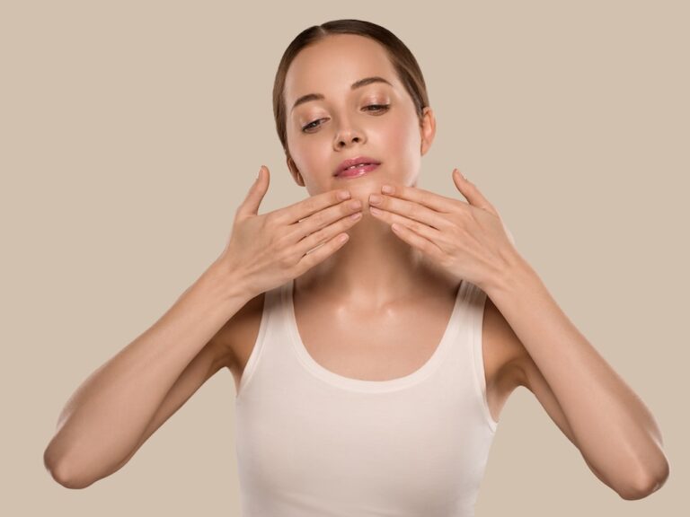 woman applying facial techniques to her face to tighten skin