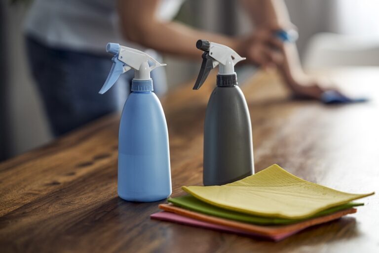 two reusable spray bottles on a table with cloths