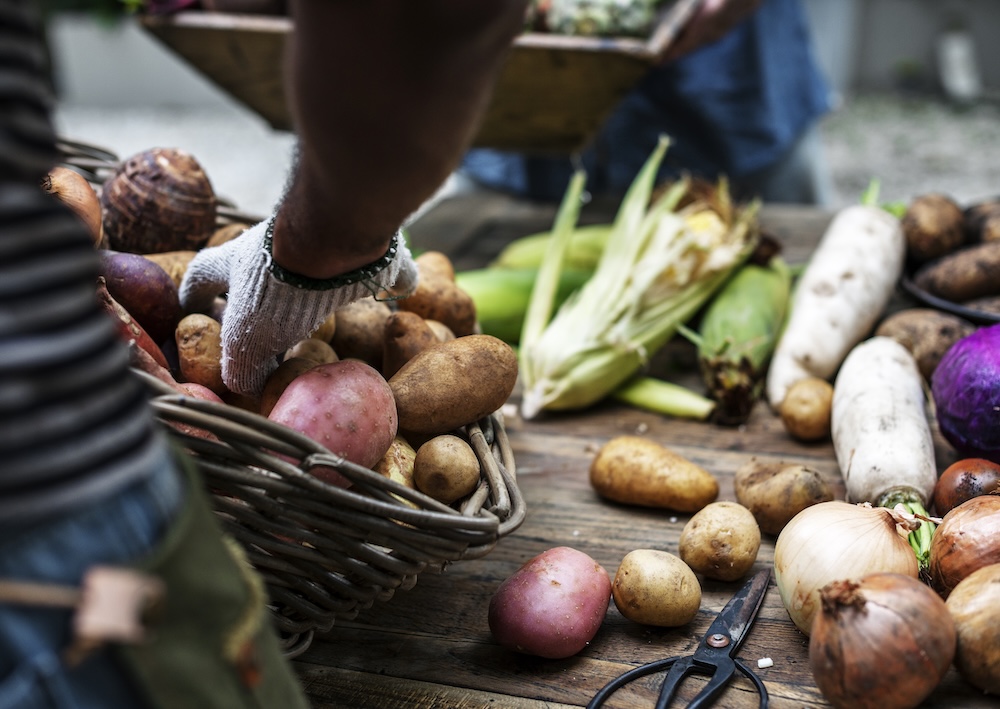 close up of someone arranging vegetables in a wood box