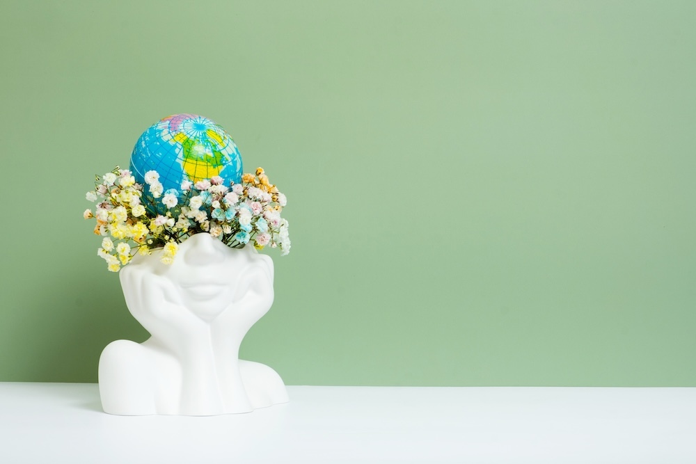 vase shaped like a head with earth on top