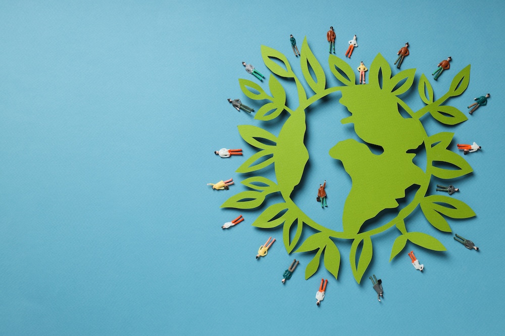green earth with people standing around working towards sustainability