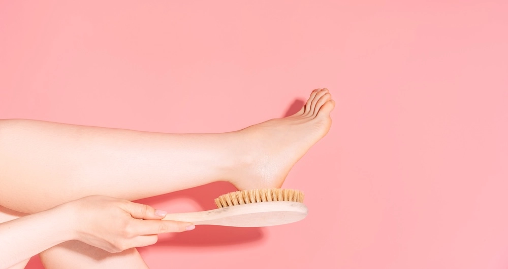 woman using a natural brush on her feet