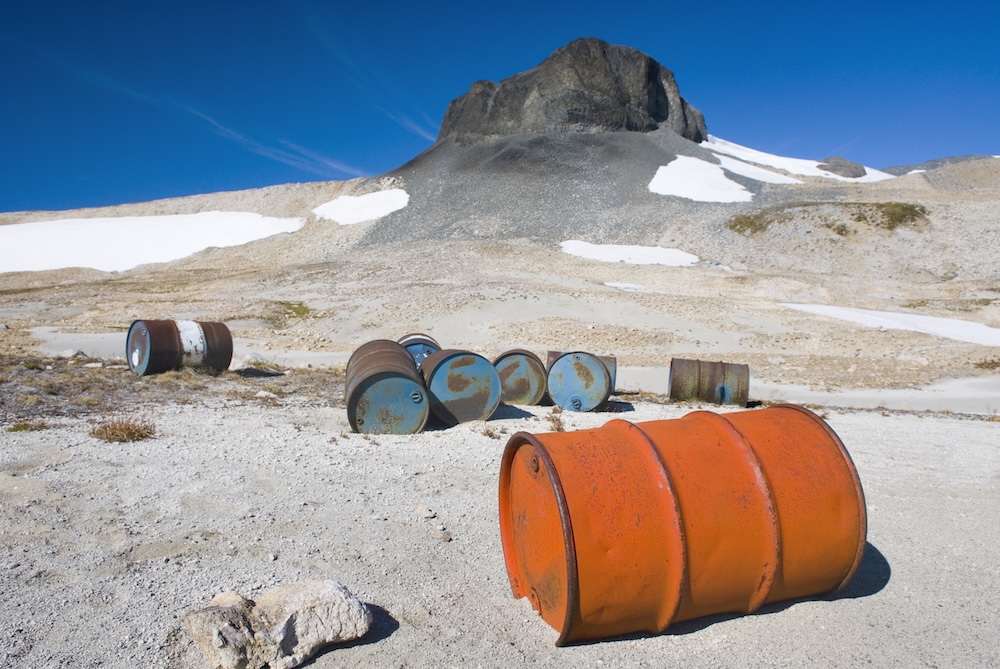 Fuel drums dumped on land in dirt and snow