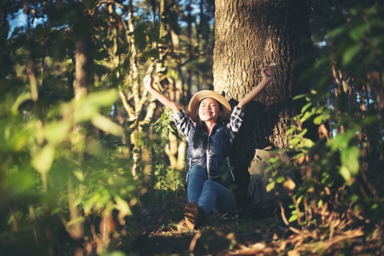 woman seated on the ground in a forest forest bathing