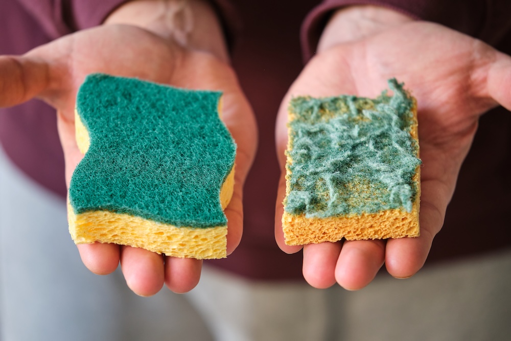person holding a clean and a dirty kitchen sponge made with synthetic plastic
