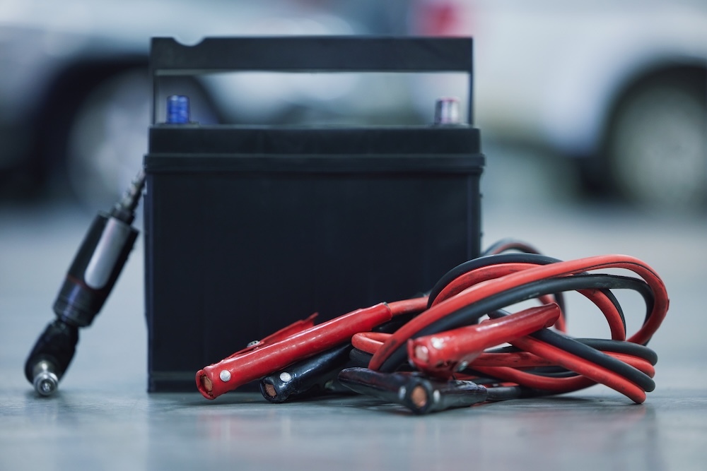 Lead acid battery with jumper cables on ground