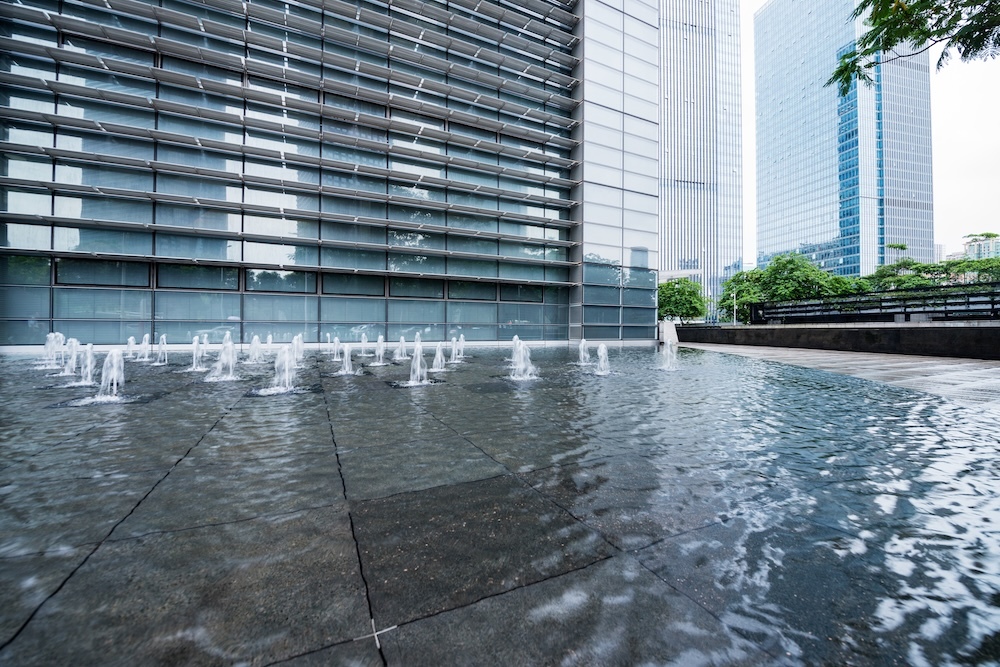 tall office building with water fountains outside
