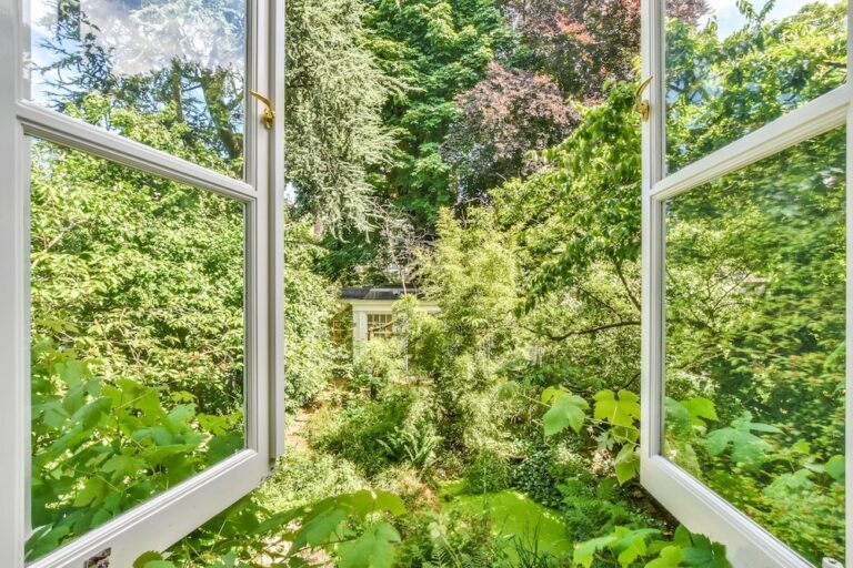 window opening to a lush and green garden