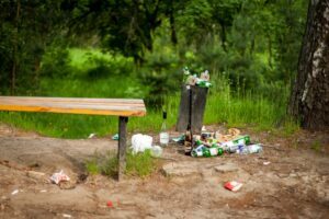 garbage overflowing a trash can in nature