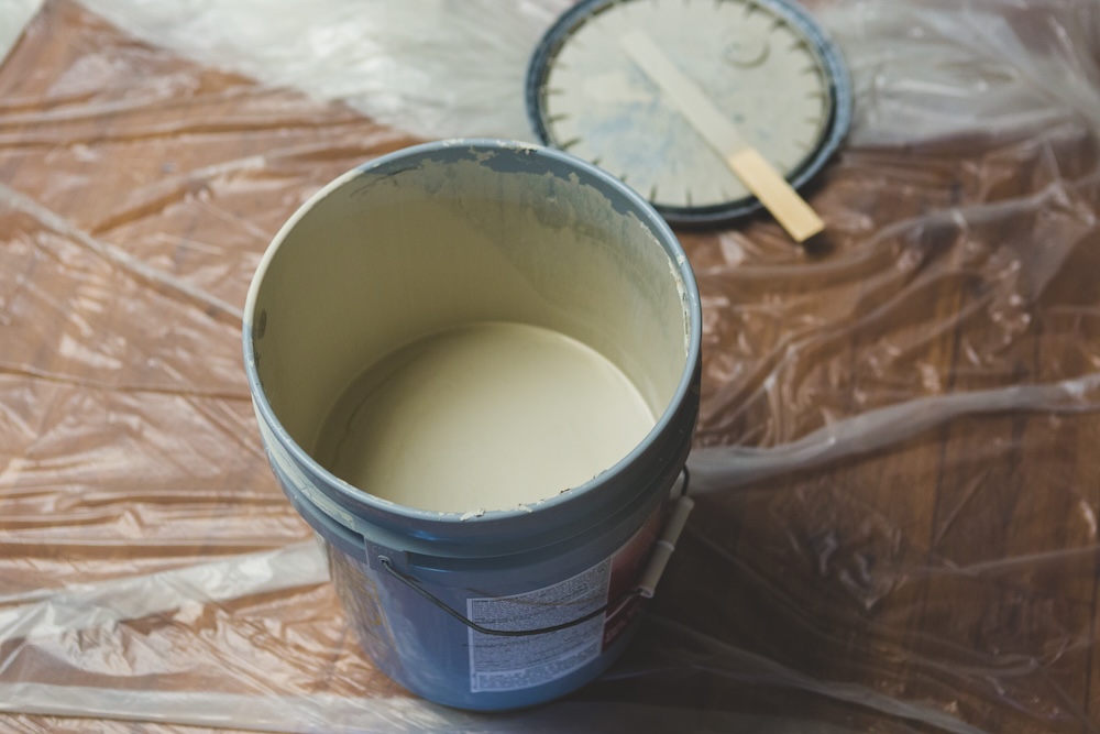 paint bucket on the floor with a paint stick