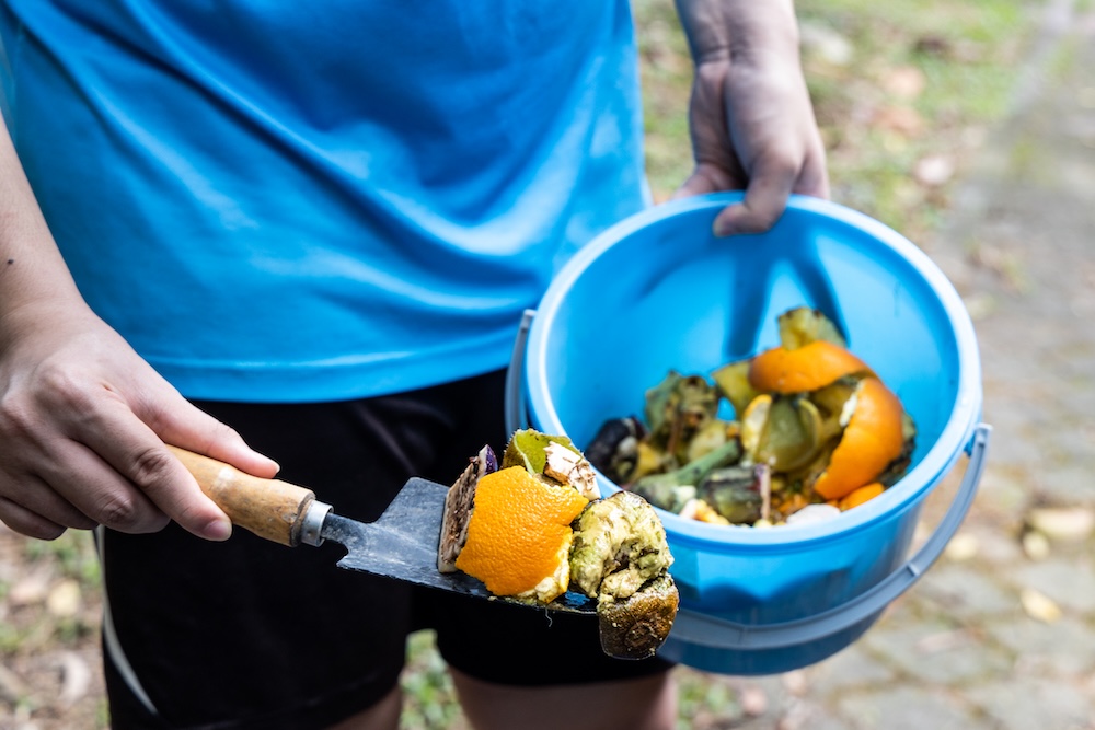 person holding compost shovel and bucket