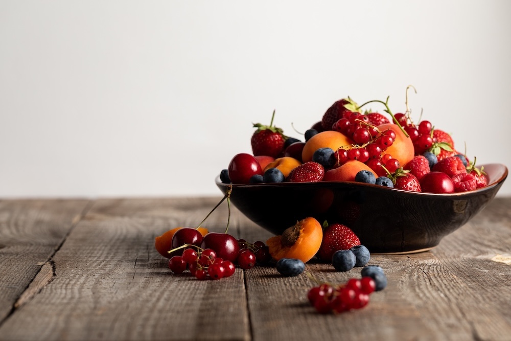 mixed bowl of fruits and berries sitting on a table