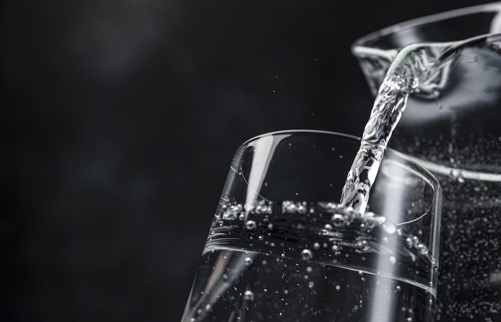 pouring water into a cup on a black background