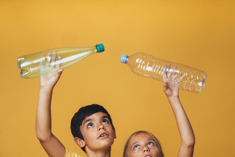 two little kids holding plastic bottles