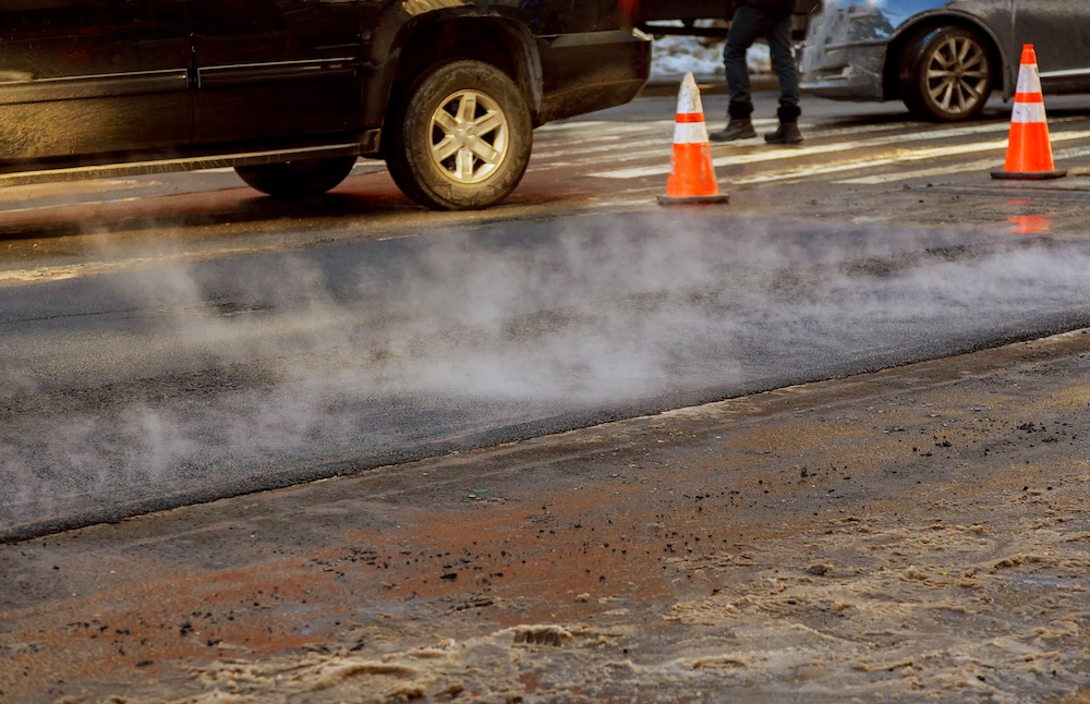 cars on a road with asphalt giving of fumes into the air
