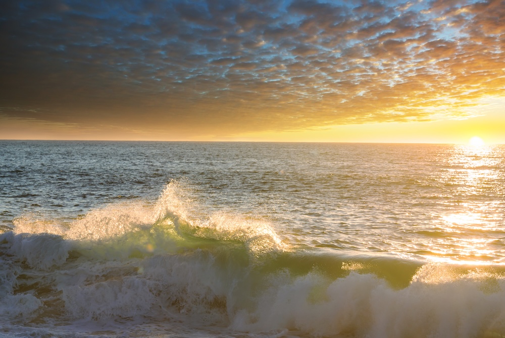 ocean waves crashing with the sun warming up the water