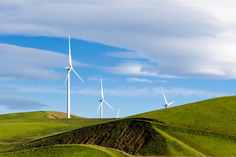 wind turbines on hills with blue sky