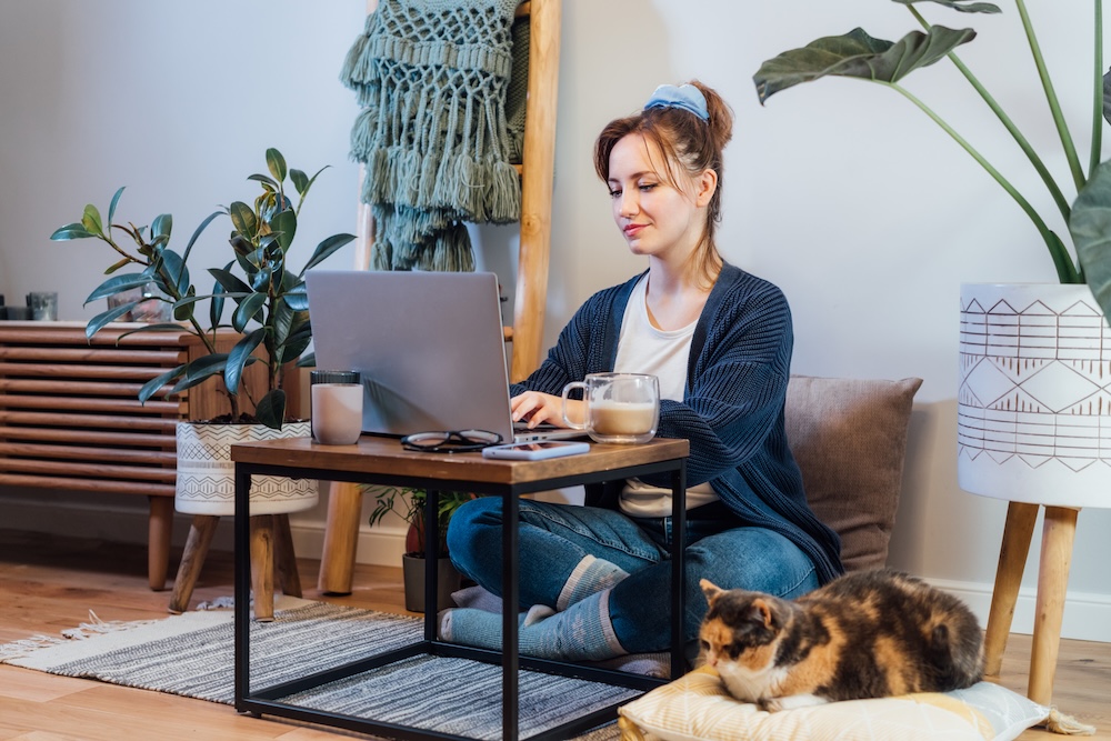 young woman working from home on a small floor desk