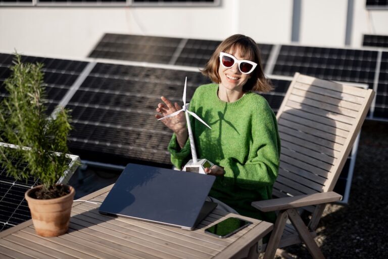woman sitting at a desk next to solar panels