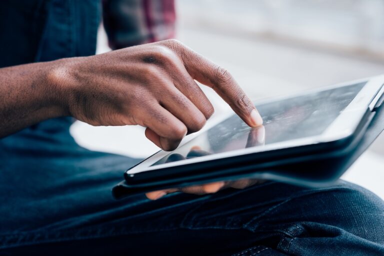 young man scrolling on his ipad reading news