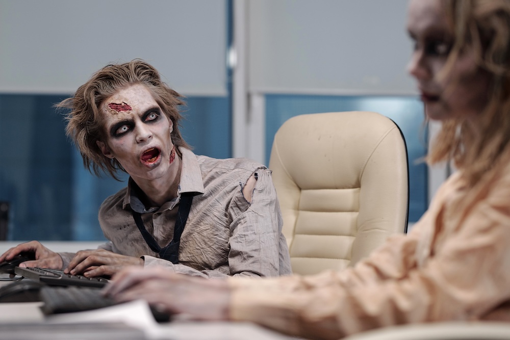 zombie workers sitting at their desks in an office