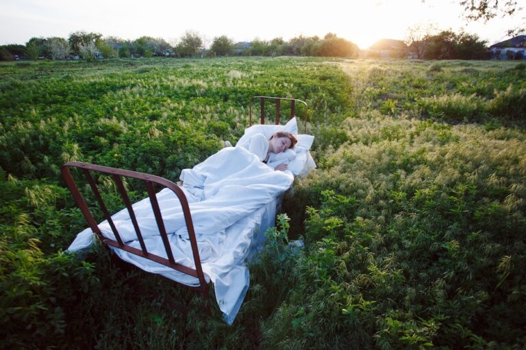 women sleeping in her bed in a green field