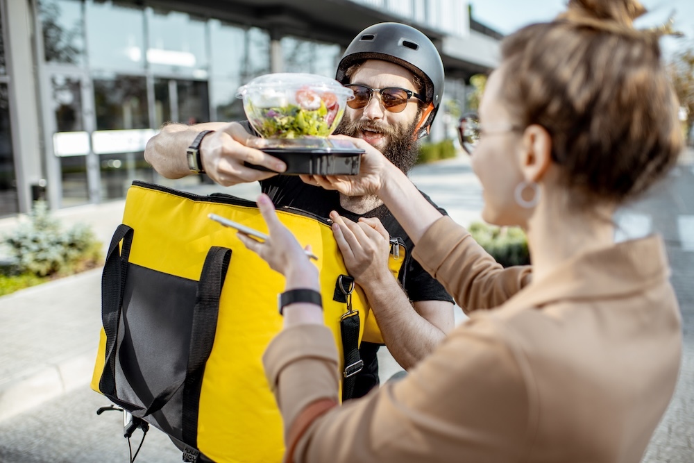 food delivery man giving food to woman