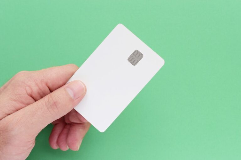 hand holding a credit card against a green background